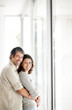 Foto: Happy mature couple embracing near a window Happy mature couple embracing near a window