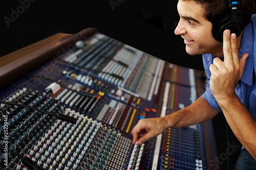 Photo: Sound recording studio - Young guy working with synthesizer Sound recording studio - Young guy working with synthesizer