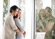 Foto: Cosy mature couple standing near a window at home Cosy mature couple standing near a window at home