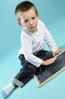 serious white little boy studying on black borad serious white little boy studying on black borad