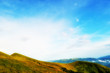 Cloudy blue sky upon green mountain ridge Cloudy blue sky upon green mountain ridge