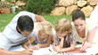 parents painting with their children lying in the garden