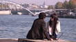 Video: romantic couple sitting along the river Seine romantic couple sitting along the river Seine