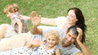family lying in the garden looking at the camera