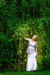beautiful pregnant woman stands in the willow garden beautiful pregnant woman stands in the willow garden
