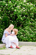 Cute girl kiss her mother in blooming garden Cute girl kiss her mother in blooming garden
