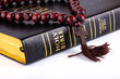bible with a rosary on a white background