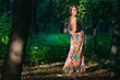 Beautiful well-dressed woman in the green wild forest Beautiful well-dressed woman in the green wild forest