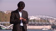 businessman in suit working outdoors with river in background