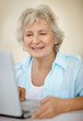 Happy senior woman working on a laptop