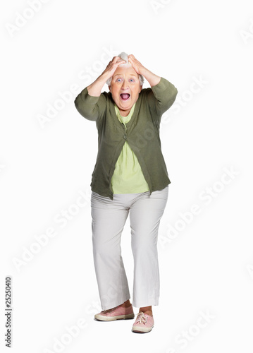 Photo: Shocked elderly woman with hands on head isolated against white Shocked elderly woman with hands on head isolated against white
