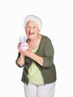 Happy mature woman holding piggy bank isolated against white