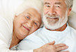Relaxed senior couple lying together on bed