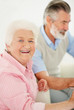 A senior man and a happy elderly female sitting together