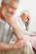 Stressed mature couple sitting on sofa after a quarrel