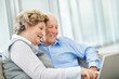 Happy mature woman with a senior man pointing at laptop