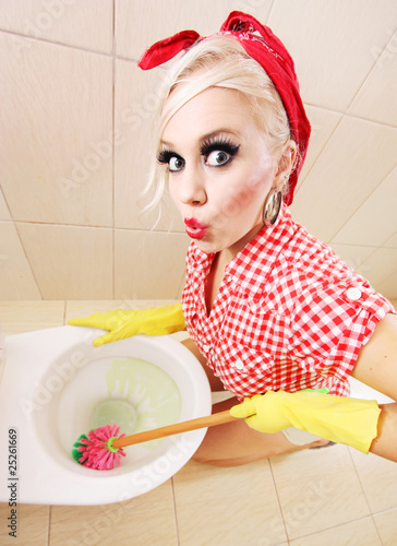 Foto: Attractive girl cleaning toilet Attractive girl cleaning toilet