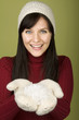 Photo: Woman in hat and mittens holding snow Woman in hat and mittens holding snow