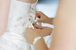 Helping the bride to put a wedding dress on