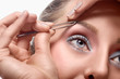 Woman tweezing eyebrow