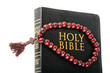bible with a rosary on a white background