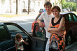 Happy parents near a new car and child here