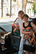 Happy parents near a new car and child here