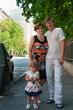 Happy parents near a new car and child here