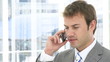caucasian businessman on phone standing in his office