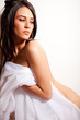 Portrait of attractive nude girl covering your body by silk