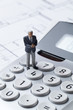 homme d'affaires miniature sur calculette