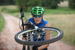 Photo: Biker looking at spokes in wheel of his bike Biker looking at spokes in wheel of his bike