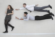 businesswoman standing, businessmen flying in superman pose, side view