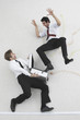 two businessmen, one holding suitcase, the other scaring him, elevated view