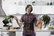 Photo: germany, berlin, young man in kitchen holding bunch of carrots and spring onions, laughing, portrait germany, berlin, young man in kitchen holding bunch of carrots and spring onions, laughing, portrait