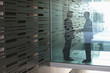 Foto: germany, cologne, businessmen shaking hands behind glass door germany, cologne, businessmen shaking hands behind glass door