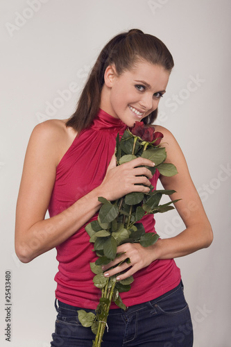 Photo: young woman holding a bouquet of roses young woman holding a bouquet of roses