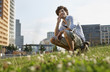 germany, berlin, young man using mobile phone, smiling, portrait