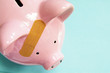 pink piggy bank with a bandage (healthcare costs) pink piggy bank with a bandage (healthcare costs)