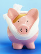pink piggy bank with bandaid, on blue pink piggy bank with bandaid, on blue