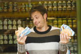 Photo: germany, bavaria, munich, viktualienmarkt, man in front of market stall holding bread rolls, portrait germany, bavaria, munich, viktualienmarkt, man in front of market stall holding bread rolls, portrait