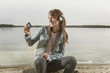 germany, berlin, lake wannsee, woman wearing headphones