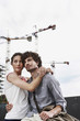 germany, berlin, young couple in front of new building, cranes in background