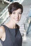 Photo: germany, bavaria, munich, business woman at subway station, smiling, portrait, close-up germany, bavaria, munich, business woman at subway station, smiling, portrait, close-up