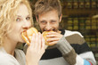 germany, bavaria, munich, young couple at viktualienmarkt having snack, portrait