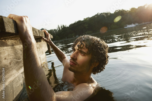 Photo: germany, berlin, young man in spree river, side view germany, berlin, young man in spree river, side view