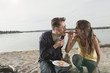 germany, berlin, lake wannsee, young couple having a barbecue