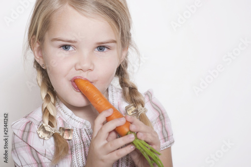 Photo: Deutschland, Mädchen mit Zöpfen essen eine Karotte, Portrait, close-up Deutschland, Mädchen mit Zöpfen essen eine Karotte, Portrait, close-up