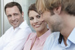 germany, cologne, three business people side by side talking, smiling, portrait