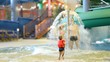 woman, man under fountain, and girl shoot at them with water gun woman, man under fountain, and girl shoot at them with water gun